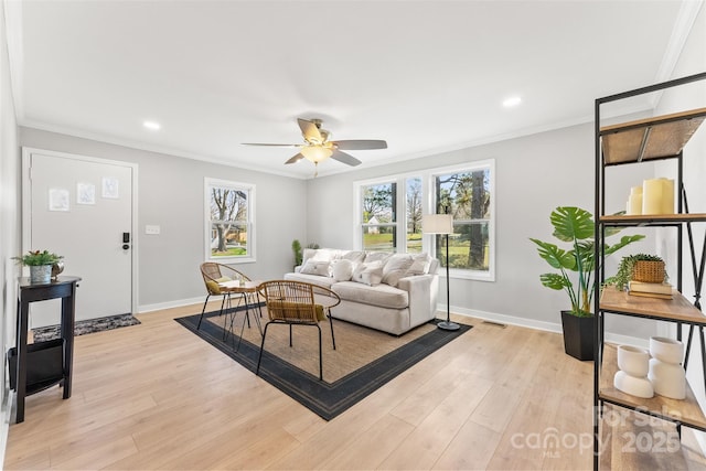 living area featuring ceiling fan, baseboards, ornamental molding, recessed lighting, and light wood-style floors