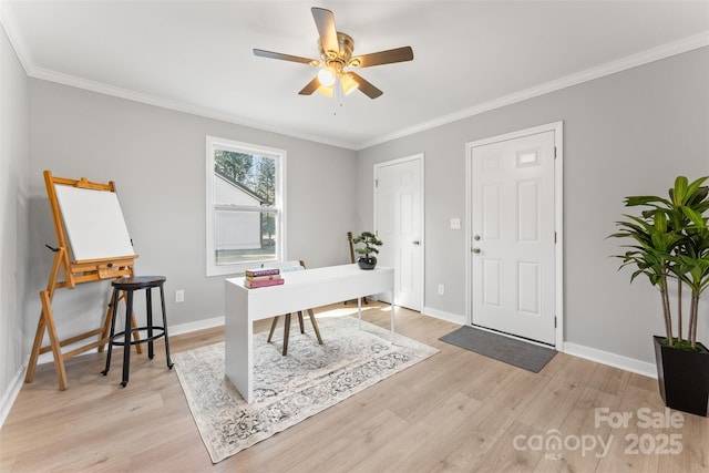 office area featuring baseboards, light wood-type flooring, a ceiling fan, and ornamental molding