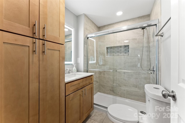 bathroom with vanity, toilet, a shower stall, and tile patterned flooring