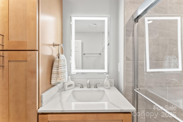 bathroom featuring tiled shower and vanity