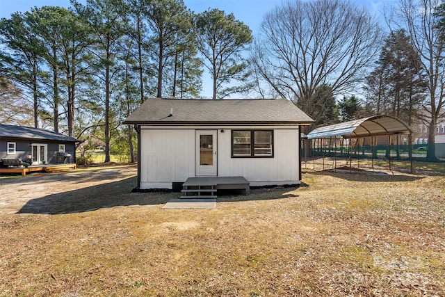 view of outbuilding featuring an outbuilding, a carport, and fence