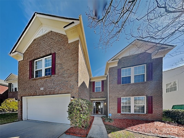 traditional-style house featuring an attached garage, brick siding, and driveway