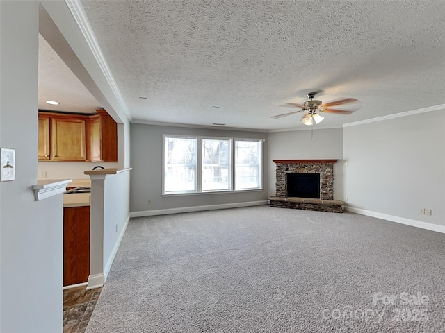 unfurnished living room featuring ornamental molding, a ceiling fan, carpet, a stone fireplace, and baseboards