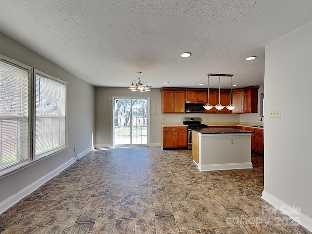 kitchen with a notable chandelier, a center island, baseboards, and stainless steel appliances