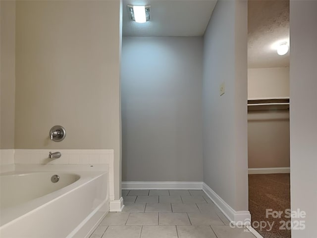 full bath with tile patterned flooring, visible vents, baseboards, a garden tub, and a textured ceiling