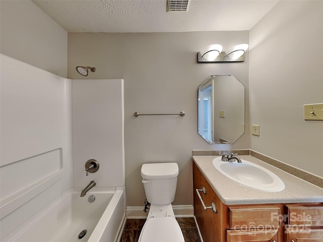 bathroom featuring visible vents, toilet, vanity, a textured ceiling, and  shower combination