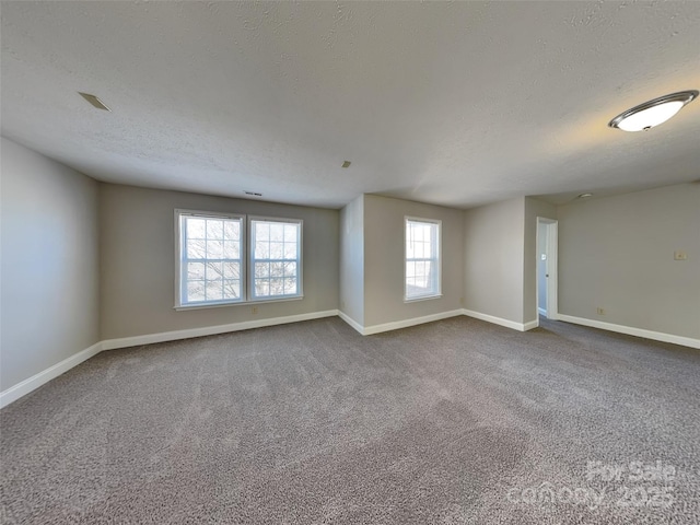 unfurnished room featuring a textured ceiling, baseboards, and dark colored carpet