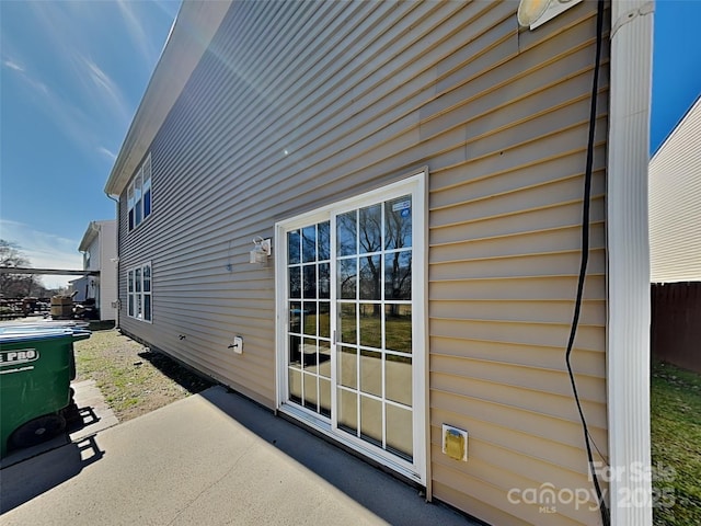 view of home's exterior with a patio area and fence