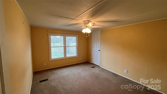 carpeted spare room featuring baseboards, visible vents, a textured ceiling, and ceiling fan