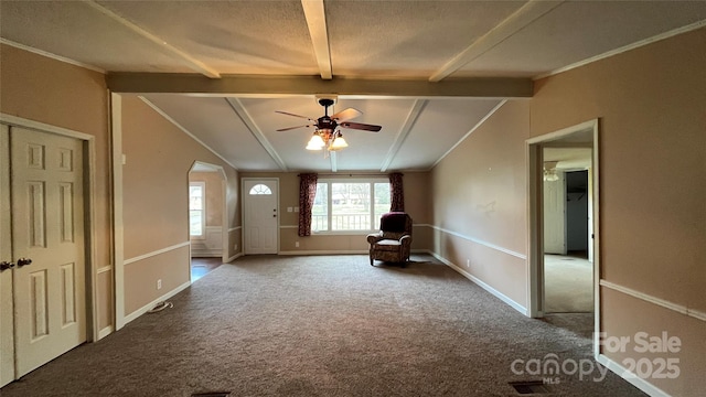 unfurnished room with baseboards, carpet floors, vaulted ceiling with beams, arched walkways, and ceiling fan