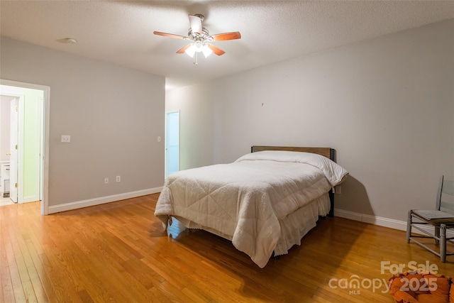 bedroom with baseboards, light wood-style floors, a ceiling fan, and a textured ceiling