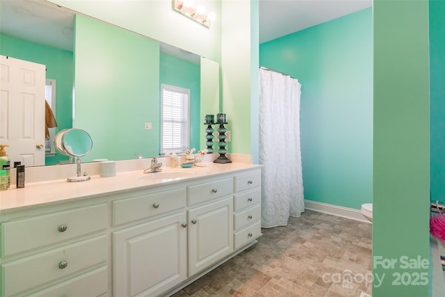 full bathroom featuring vanity, a shower with shower curtain, toilet, and baseboards