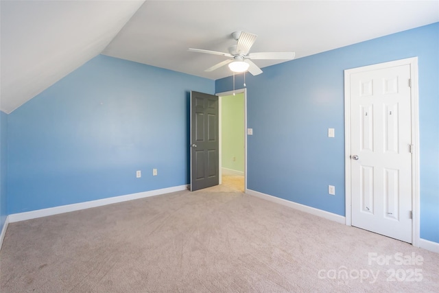 unfurnished bedroom featuring vaulted ceiling, carpet flooring, a ceiling fan, and baseboards