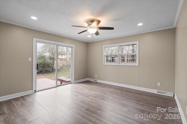 unfurnished room featuring wood finished floors, baseboards, visible vents, ceiling fan, and a textured ceiling