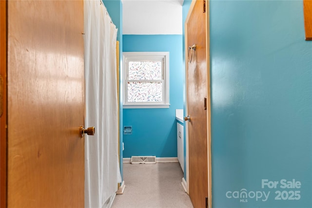 hallway with visible vents and baseboards