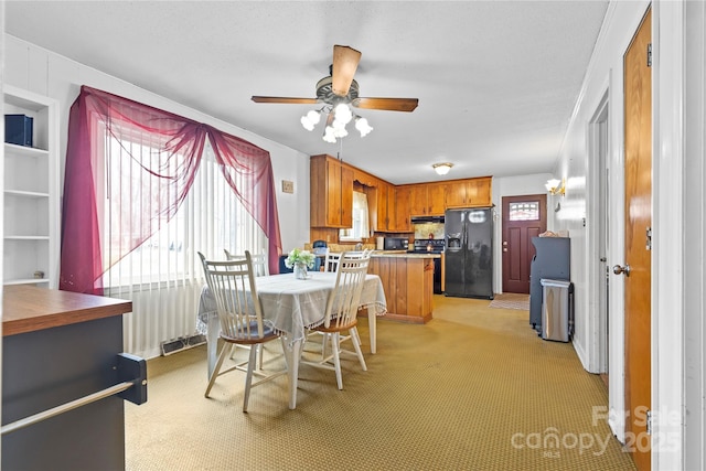 dining room featuring light colored carpet and a ceiling fan