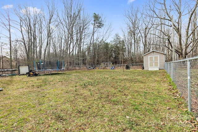 view of yard with an outbuilding, a fenced backyard, a storage unit, a playground, and a trampoline