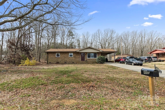 view of front of property with driveway, a shingled roof, crawl space, an attached carport, and brick siding