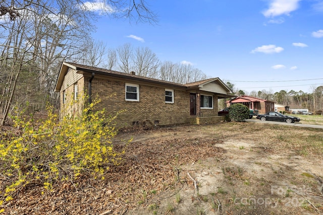 view of home's exterior with crawl space and brick siding