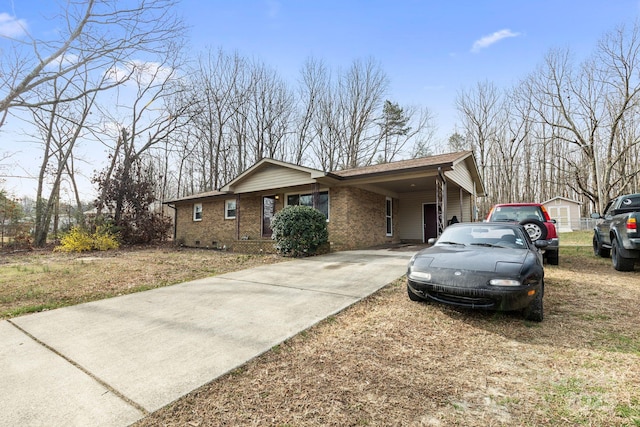 view of front of house with a carport, concrete driveway, and brick siding