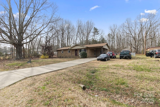 view of front of property featuring an attached carport, concrete driveway, and a front lawn