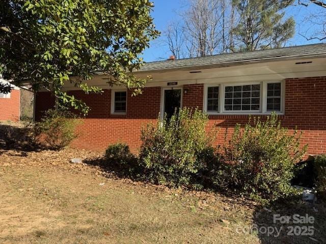 single story home featuring brick siding