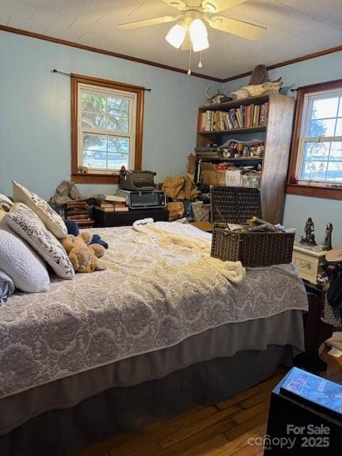 bedroom featuring ceiling fan, wood finished floors, and crown molding