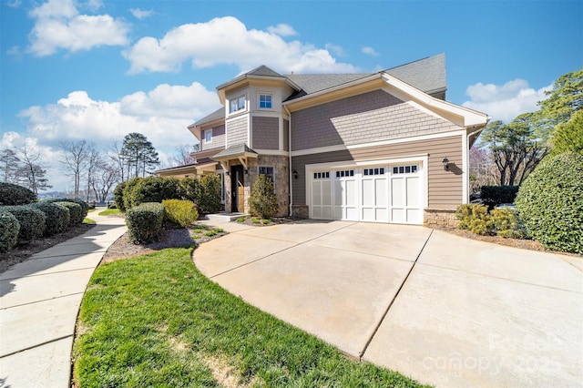 view of front of house with stone siding, an attached garage, and concrete driveway