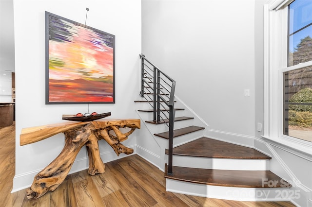 stairway featuring wood finished floors and baseboards