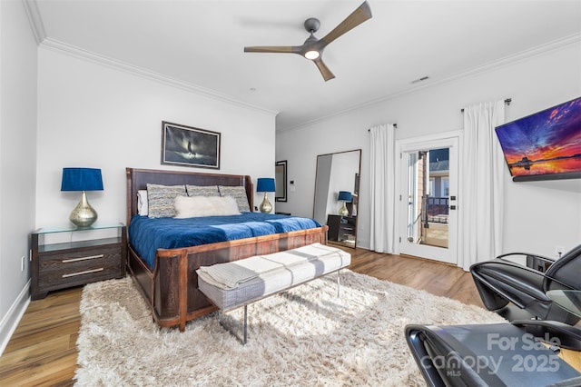 bedroom with visible vents, wood finished floors, ornamental molding, and access to exterior