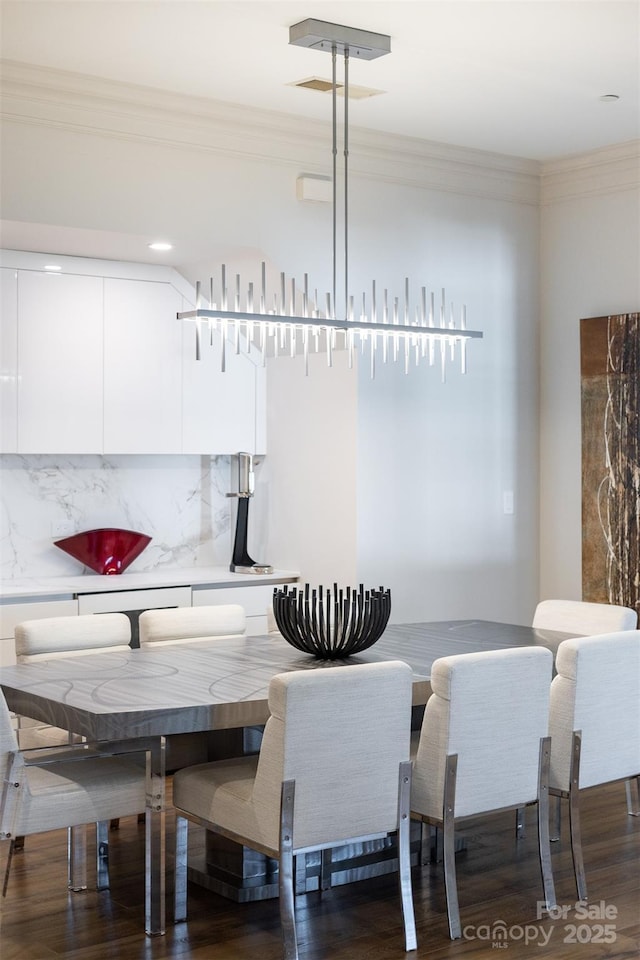 dining room featuring wood finished floors and ornamental molding