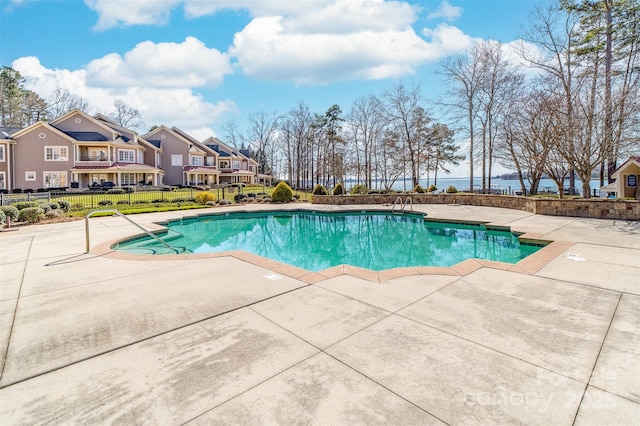 community pool with a residential view, a patio, and fence