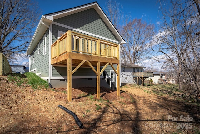 back of house with crawl space, a deck, and stairs