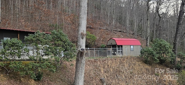 view of yard with a storage unit, an outdoor structure, and fence