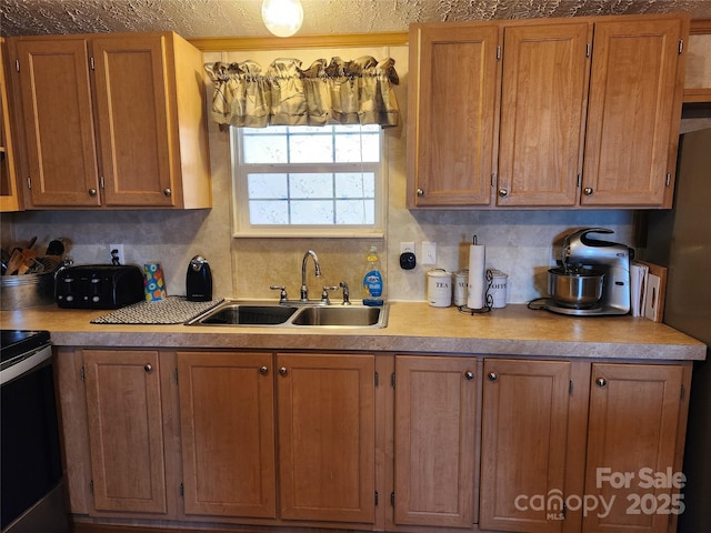 kitchen with light countertops, decorative backsplash, brown cabinets, electric range, and a sink