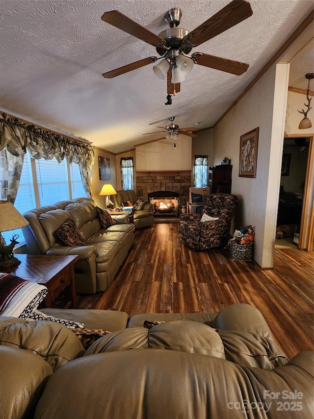 living area with a wealth of natural light, lofted ceiling, and wood finished floors