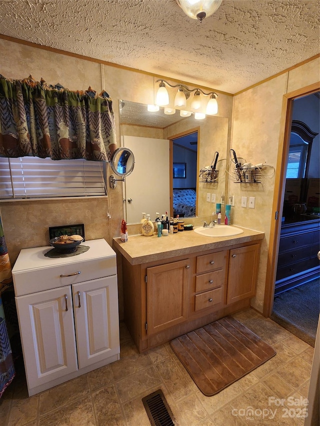 bathroom featuring connected bathroom, a textured ceiling, visible vents, and vanity