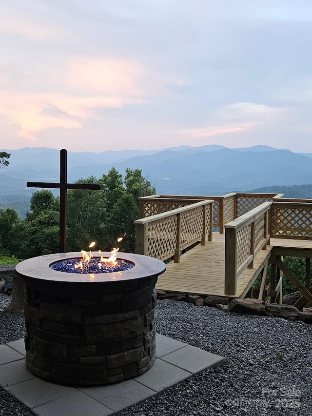 view of patio / terrace featuring a deck with mountain view and an outdoor fire pit