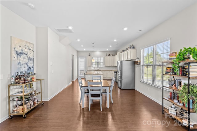 dining space featuring a wealth of natural light, visible vents, dark wood-type flooring, and baseboards