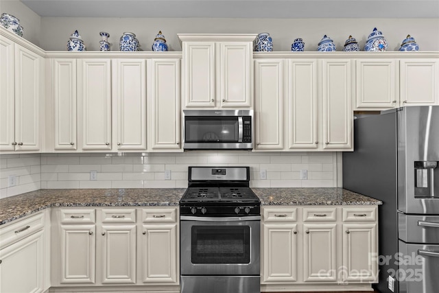 kitchen featuring dark stone countertops, decorative backsplash, and appliances with stainless steel finishes