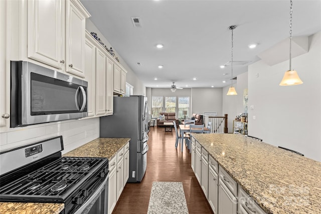 kitchen featuring a ceiling fan, stainless steel appliances, dark wood-type flooring, open floor plan, and backsplash