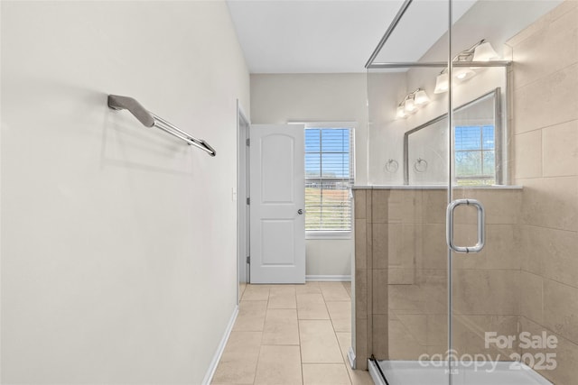 bathroom with tile patterned floors, a shower stall, and baseboards