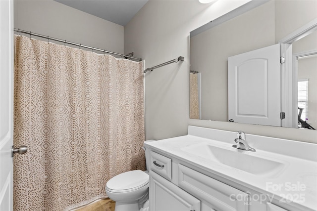 bathroom featuring a shower with shower curtain, toilet, and vanity