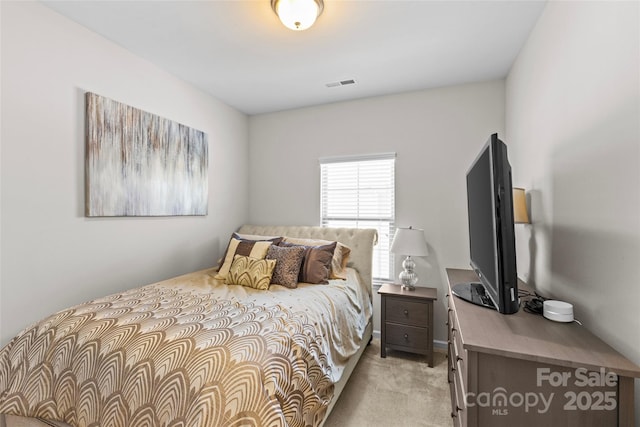 bedroom with visible vents and light carpet