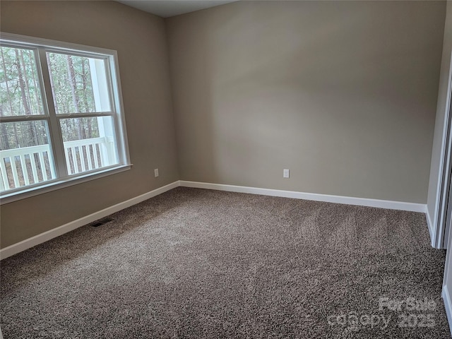 carpeted empty room featuring baseboards and visible vents