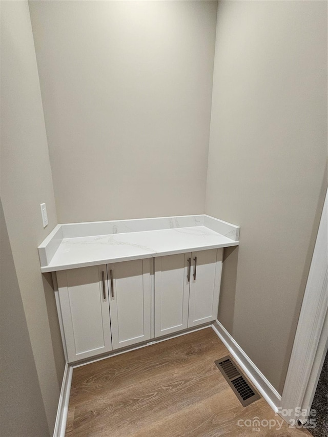 interior space featuring visible vents, baseboards, and wood finished floors