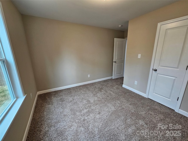 unfurnished bedroom with carpet flooring and baseboards