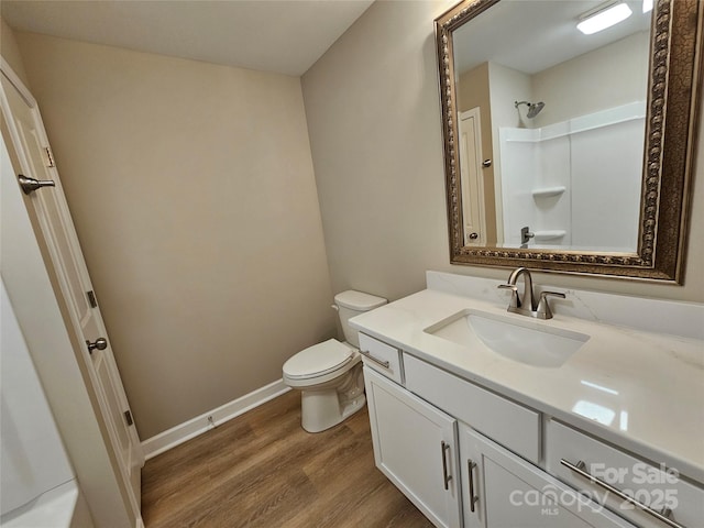 full bathroom with baseboards, walk in shower, toilet, wood finished floors, and vanity