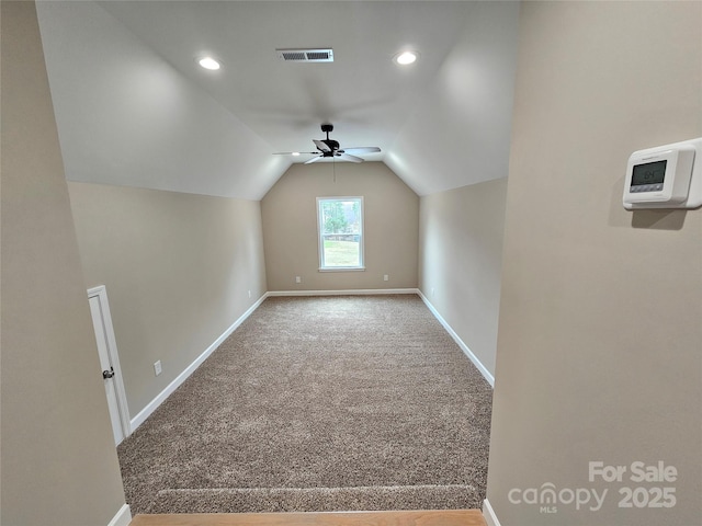 additional living space featuring visible vents, lofted ceiling, a ceiling fan, carpet flooring, and baseboards