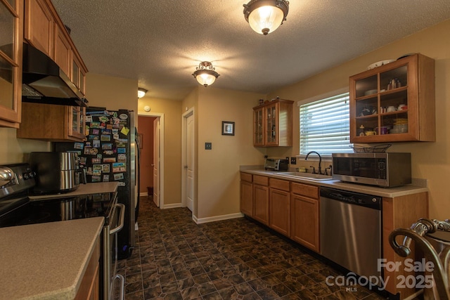 kitchen featuring a sink, extractor fan, appliances with stainless steel finishes, and brown cabinetry